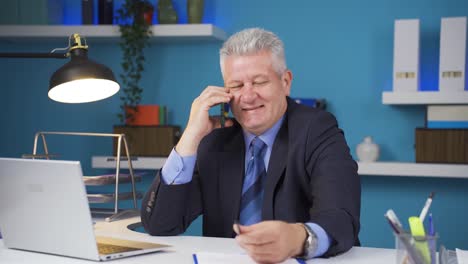 Happy-businessman-using-phone-laughing.